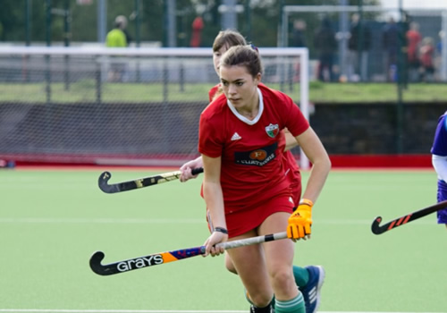 hockey player in red running with the ball