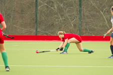 hockey player at full stretch going for the ball