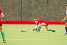 hockey player at full stretch going for the ball